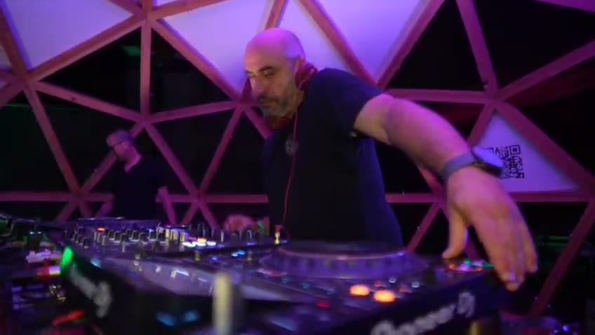 DJ booth sous dôme géodésique mappé en violet, festival électro 2025